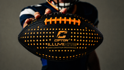 Player in a helmet holding out the glowing CIPTON LED football