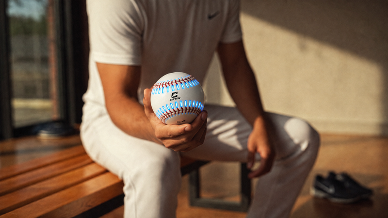 Man seated on a bench holding a CIPTON LED baseball with glowing blue seams