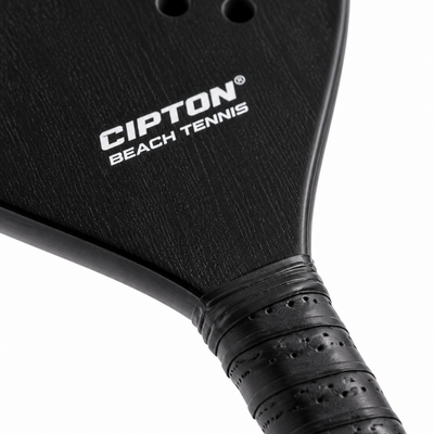 Close-up of the CIPTON Beach Tennis paddle face and wrapped grip