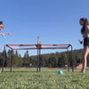 CIPTON Slam Pong Pro on a field, two players rallying over the center net with paddles, then hands